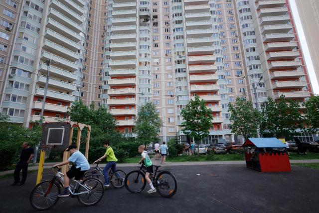 Children ride their bycicles in the courtyard of a damaged residential building following an air attack in Krasnogorsk, Moscow region on May 17, 2026, amid the ongoing Russian-Ukrainian conflict. A wave of almost 600 Ukrainian drones attacked Russia overnight killing four people, authorities said on May 17, 2026, as Ukraine's President Volodymyr Zelensky called the barrage an 'entirely justified' retribution for Moscow's own pummelling of Ukraine. (Photo by TATYANA MAKEYEVA / AFP)