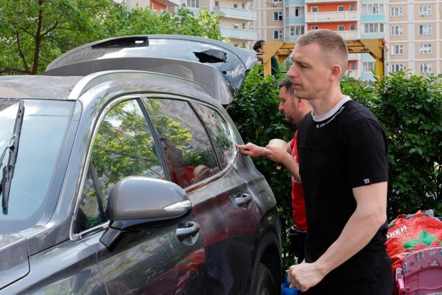 Local residents inspect a damaged car in the courtyard of a residential building following an air attack in Krasnogorsk, Moscow region on May 17, 2026, amid the ongoing Russian-Ukrainian conflict. A wave of almost 600 Ukrainian drones attacked Russia overnight killing four people, authorities said on May 17, 2026, as Ukraine's President Volodymyr Zelensky called the barrage an 'entirely justified' retribution for Moscow's own pummelling of Ukraine. (Photo by TATYANA MAKEYEVA / AFP)
