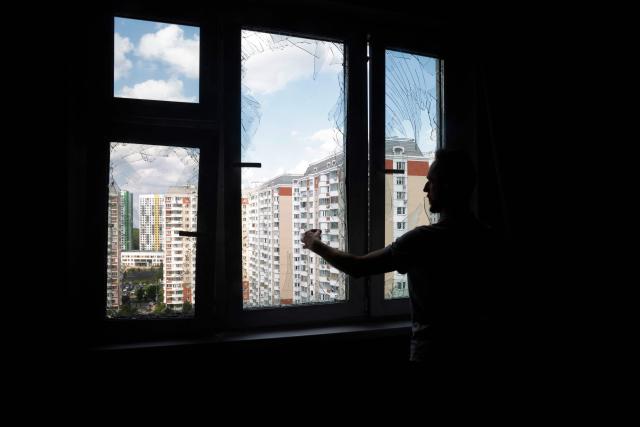 A local resident removes glass shards from a broken window in a residential building following an air attack in Krasnogorsk, Moscow region on May 17, 2026, amid the ongoing Russian-Ukrainian conflict. A wave of almost 600 Ukrainian drones attacked Russia overnight killing four people, authorities said on May 17, 2026, as Ukraine's President Volodymyr Zelensky called the barrage an 'entirely justified' retribution for Moscow's own pummelling of Ukraine. (Photo by TATYANA MAKEYEVA / AFP)