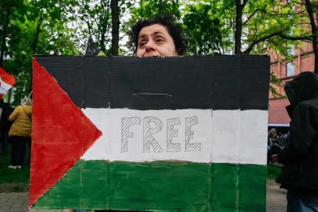 A protester holds a Palestinian flag during a demonstration in solidarity with the Palestinian people, on May 17, 2026, in Brussels. (Photo by Marius BURGELMANS / Belga / AFP) / Belgium OUT