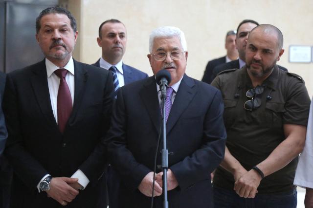 (FILES) Palestinian president Mahmud Abbas, flanked by his two sons Yasser (L) and Tarek (R), gives a short statement before leaving a hospital near Ramallah in the occupied West Bank on May 28, 2018 following eight days of treatment for pneumonia. The son of Palestinian president Mahmoud Abbas won a seat on Fatah's top decision-making body on May 17, 2026, as initial results emerged from the Palestinian movement's first congress in a decade. Yasser Abbas, 64, a businessman who spends most of his time in Canada, secured a place on the central committee after being appointed around five years ago as his father's "special representative"  a role that marked his emergence. (Photo by ABBAS MOMANI / AFP)