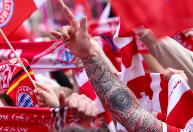 A fan with Bayern Munich's tatoos gestures as Bayern Munich's players celebrate their 35th Bundesliga championship title at the City Hall at Marienplatz in Munich, southern Germany, on May 17, 2026. (Photo by Alexandra BEIER / AFP)