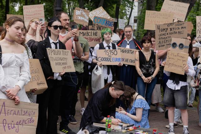Protesters hold placards as they take part in a demonstration against the new Civil Code, warning it could restrict the rights of women, children, people with disabilities, and the LGBTQ community by regulating issues such as abortion, early marriage, and alimony in Kyiv on May 17, 2026, amid the Russian invasion of Ukraine. (Photo by Tetiana DZHAFAROVA / AFP)