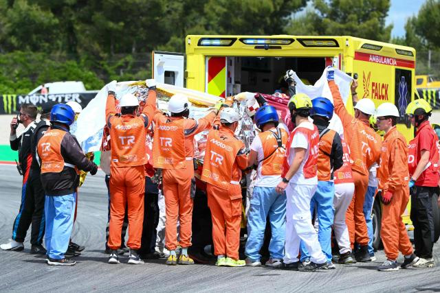 Medics and officials load Team Gresini Racing MotoGP's Alex Marquez into an ambulance following a high speed crash during the 2026 Catalunya Moto GP Grand Prix at the Catalunya racetrack in Montmelo, near Barcelona, on May 17, 2026. (Photo by JOSE JORDAN / AFP)