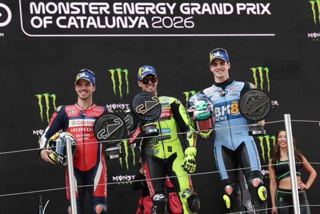 TOPSHOT - First placed Team Pertamina Enduro VR46 Racing Team's Fabio Di Giannantonio (C) celebrates on the podium with second placed Team Repsol Honda Team's Joan Mir (L) and third placed eam Gresini Racing MotoGP's Fermin Aldeguer after the 2026 Catalunya Moto GP Grand Prix at the Catalunya racetrack in Montmelo, near Barcelona, on May 17, 2026. (Photo by Lluis GENE / AFP)