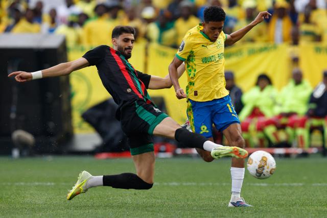 TOPSHOT - AS FAR's Moroccan defender #15 Marwan Louandi tackles Sundowns' South African forward #17 Tashreeq Matthews during the CAF Champions League final first leg football match between Mamelodi Sundowns and AS FAR (Association Sportive des Forces Armees Royales - Royal Army Club) at Loftus Versfeld Stadium in Pretoria on May 17, 2026. (Photo by Phill Magakoe / AFP)