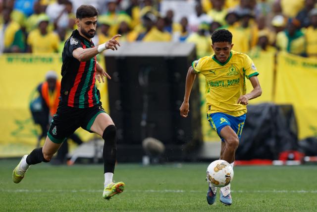 AS FAR's Moroccan defender #15 Marwan Louandi challenges Sundowns' South African forward #17 Tashreeq Matthews during the CAF Champions League final first leg football match between Mamelodi Sundowns and AS FAR (Association Sportive des Forces Armees Royales - Royal Army Club) at Loftus Versfeld Stadium in Pretoria on May 17, 2026. (Photo by Phill Magakoe / AFP)