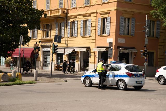 A Police car patrols in the center of Modena a day after a man drove his car into pedestrians injuring eight people, on May 17, 2026. Italian Prime Minister Giorgia Meloni visited people wounded by a driver with a history of mental health problems who ran over several pedestrians in the center of Modena, Northern Italy. The driver, a 31-year-old Italian man of Moroccan heritage, hit several people before crashing into a shop window, colliding head-on with a woman. (Photo by Federico SCOPPA / AFP)