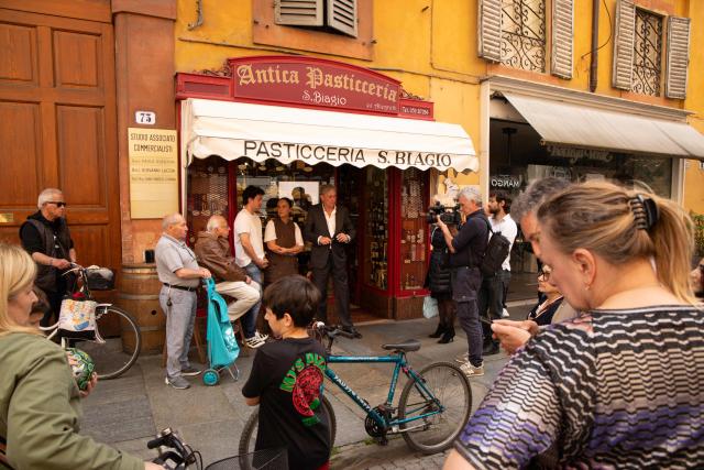 A journalist works in the center of Modena a day after a man drove his car into pedestrians injuring eight people, on May 17, 2026. Italian Prime Minister Giorgia Meloni visited people wounded by a driver with a history of mental health problems who ran over several pedestrians in the center of Modena, Northern Italy. The driver, a 31-year-old Italian man of Moroccan heritage, hit several people before crashing into a shop window, colliding head-on with a woman. (Photo by Federico SCOPPA / AFP)