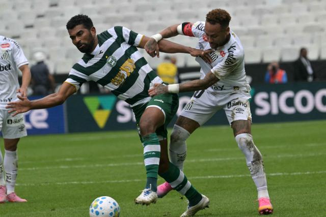 Coritiba's defender #21 Thiago Santos (L) and Santos' forward #10 Neymar fight for the ball during the Brazilian league football match between Santos and Coritiba at the Neo Quimica Arena in Sao Paulo, Brazil, on May 17, 2026. (Photo by NELSON ALMEIDA / AFP)