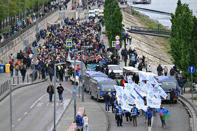 Participants to the "March of the Living" walk with banners and flags along the bank of the Danube River in downtown Budapest, Hungary, on May 17, 2026, to commemorate the Hungarian Holocaust victims. The 'March of the Living' commemorates the Holocaust victims who were deported to the concentration camps by the Nazis. (Photo by Attila KISBENEDEK / AFP)