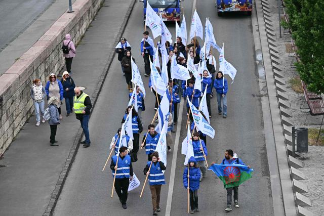 Participants to the "March of the Living" walk with banners and flags along the bank of the Danube River in downtown Budapest, Hungary, on May 17, 2026, to commemorate the Hungarian Holocaust victims. The 'March of the Living' commemorates the Holocaust victims who were deported to the concentration camps by the Nazis. (Photo by Attila KISBENEDEK / AFP)