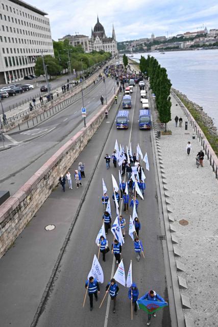 Participants to the "March of the Living" walk with banners and flags along the bank of the Danube River in downtown Budapest, Hungary, on May 17, 2026, to commemorate the Hungarian Holocaust victims. The 'March of the Living' commemorates the Holocaust victims who were deported to the concentration camps by the Nazis. (Photo by Attila KISBENEDEK / AFP)