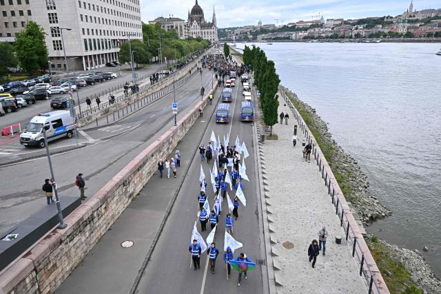 Participants to the "March of the Living" walk with banners and flags along the bank of the Danube River in downtown Budapest, Hungary, on May 17, 2026, to commemorate the Hungarian Holocaust victims. The 'March of the Living' commemorates the Holocaust victims who were deported to the concentration camps by the Nazis. (Photo by Attila KISBENEDEK / AFP)