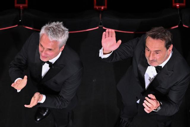 (From Top L) French producer Alain Goldman and French actor Gilles Lellouche wave at the end of the screening of the film "Moulin" at the 79th edition of the Cannes Film Festival in Cannes, southern France on May 17, 2026. (Photo by Antonin THUILLIER / AFP)