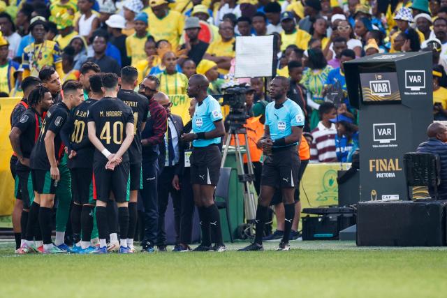 Match officials have a discussion with AS FAR players and their management to resume the second half of the match after a delay without VAR, after it failed, during the CAF Champions League final first leg football match between Mamelodi Sundowns and ASFAR (Association Sportive des Forces Armees Royales - Royal Army Club) at Loftus Versfeld Stadium in Pretoria on May 17, 2026. (Photo by Phill Magakoe / AFP)
