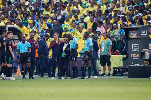 Match officials have a discussion to resume the second half of the match after a delay without VAR, after it failed, during the CAF Champions League final first leg football match between Mamelodi Sundowns and ASFAR (Association Sportive des Forces Armees Royales - Royal Army Club) at Loftus Versfeld Stadium in Pretoria on May 17, 2026. (Photo by Phill Magakoe / AFP)