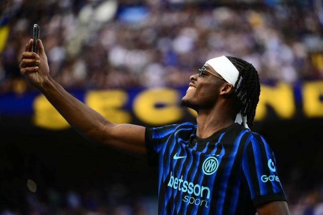 Inter Milan's German defender #31 Yann Aurel Bisseck holds his phone as Inter Milan's players perpare to celebrate their 21st scudetto (Italian Championship victory) at San Siro stadium after the Italian Serie A football match between Inter Milan and Hellas Verona in Milan, on May 17, 2026. (Photo by Marco BERTORELLO / AFP)