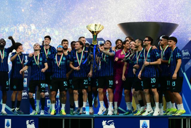 Inter Milan's Argentinian forward #10 Lautaro Martinez lifts the trophy to celebrate with teammates their 21st scudetto (Italian Championship victory) at San Siro stadium after the Italian Serie A football match between Inter Milan and Hellas Verona in Milan, on May 17, 2026. (Photo by Marco BERTORELLO / AFP)