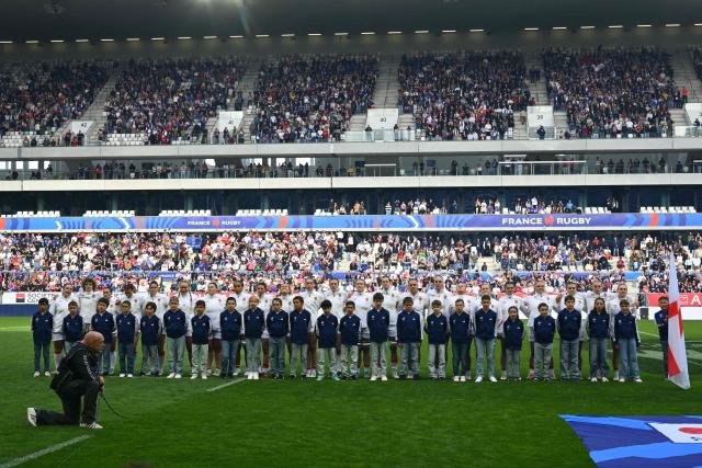 England's players stand alongside their mascots for the national anthems ahead of the Women's Six Nations international rugby union match between France and England at the Stade Atlantique in Bordeaux on May 17, 2026. (Photo by GAIZKA IROZ / AFP)