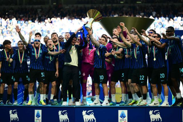 Inter Milan's Argentinian forward #10 Lautaro Martinez lifts the trophy with Inter Milan's Romanian head coach Cristian Chivu to celebrate with teammates their 21st scudetto (Italian Championship victory) at San Siro stadium after the Italian Serie A football match between Inter Milan and Hellas Verona in Milan, on May 17, 2026. (Photo by Marco BERTORELLO / AFP)