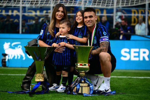 Inter Milan's Argentinian forward #10 Lautaro Martinez poses with his wife and children  behind the trophies for the Italian Cup and the 21st scudetto (Italian Championship victory) at San Siro stadium after the Italian Serie A football match between Inter Milan and Hellas Verona in Milan, on May 17, 2026. (Photo by Marco BERTORELLO / AFP)