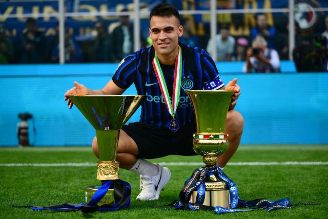 Inter Milan's Argentinian forward #10 Lautaro Martinez poses with the trophies for the Italian Cup and the 21st scudetto (Italian Championship victory) at San Siro stadium after the Italian Serie A football match between Inter Milan and Hellas Verona in Milan, on May 17, 2026. (Photo by Marco BERTORELLO / AFP)