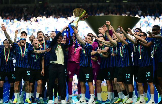 TOPSHOT - Inter Milan's Argentinian forward #10 Lautaro Martinez lifts the trophy with Inter Milan's Romanian head coach Cristian Chivu to celebrate with teammates their 21st scudetto (Italian Championship victory) at San Siro stadium after the Italian Serie A football match between Inter Milan and Hellas Verona in Milan, on May 17, 2026. (Photo by Marco BERTORELLO / AFP)