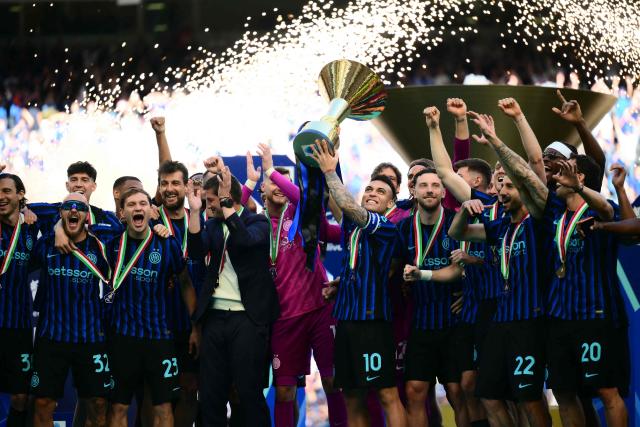 Inter Milan's Argentinian forward #10 Lautaro Martinez lifts the trophy as he celebrates with teammates their 21st scudetto (Italian Championship victory) at San Siro stadium after the Italian Serie A football match between Inter Milan and Hellas Verona in Milan, on May 17, 2026. (Photo by Marco BERTORELLO / AFP)