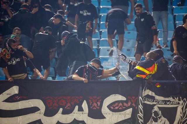 AS FAR supporters clash with South African Police Service (SAPS) officers in the stands during the CAF Champions League final first leg football match between Mamelodi Sundowns and AS FAR (Association Sportive des Forces Armees Royales - Royal Army Club) at Loftus Versfeld Stadium in Pretoria on May 17, 2026. (Photo by Phill Magakoe / AFP)