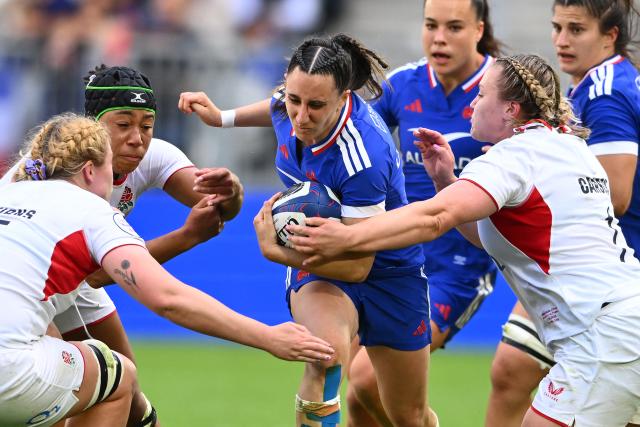France's wing Anaïs Grando (C) is tackled by England's prop Mackenzie Carson (R) and England's second row Delaney Burns (L) as she runs with the ball during the Women's Six Nations international rugby union match between France and England at the Stade Atlantique in Bordeaux on May 17, 2026. (Photo by GAIZKA IROZ / AFP)