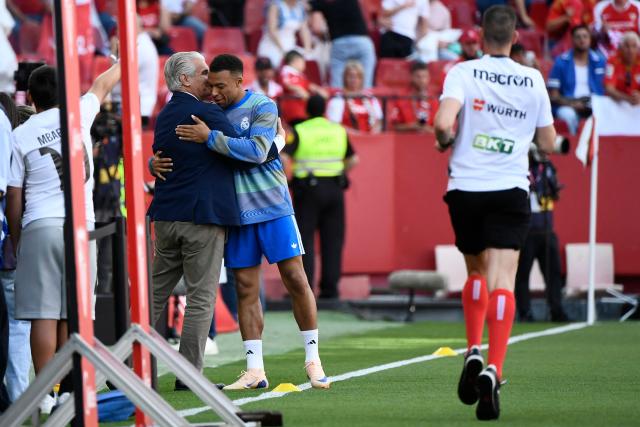 Sevilla's Sports Director Antonio Cordon Ruiz (L) hugs Real Madrid's French forward #10 Kylian Mbappe before the Spanish league football match between Sevilla FC and Real Madrid CF at the Sanchez Pizjuan stadium in Seville on May 17, 2026. (Photo by CRISTINA QUICLER / AFP)