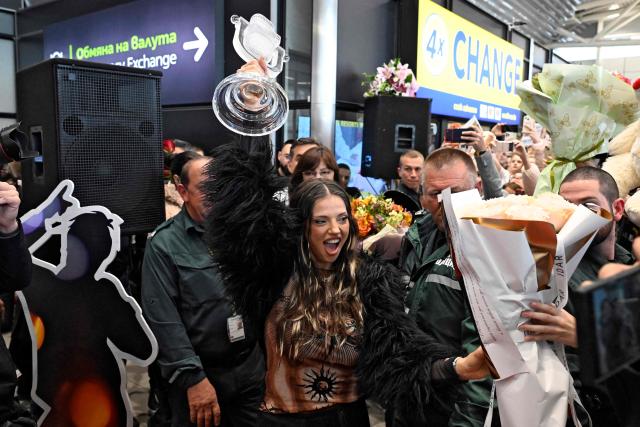 Bulgarian singer Dara lifts her trophy as she is welcomed by supporters upon her arrival in Sofia, one day after winning the Eurovision Song Contest with her song "Bangaranga," on May 17, 2026. (Photo by Nikolay DOYCHINOV / AFP)