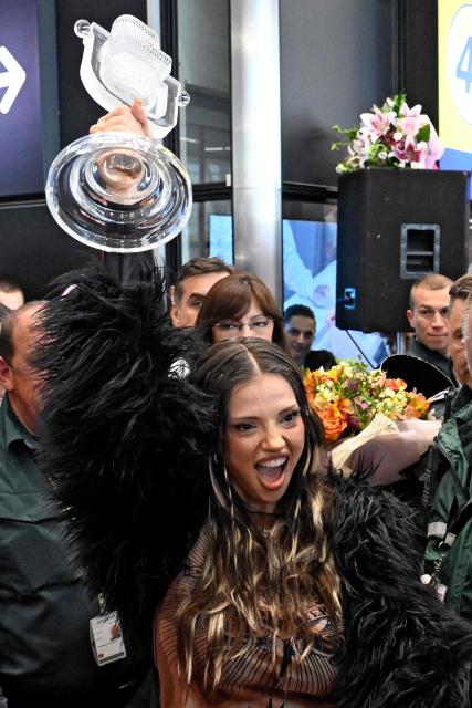 Bulgarian singer Dara lifts her trophy as she is welcomed by supporters upon her arrival in Sofia, one day after winning the Eurovision Song Contest with her song "Bangaranga," on May 17, 2026. (Photo by Nikolay DOYCHINOV / AFP)