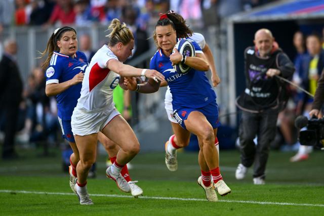 France's wing Léa Murie (CR) hands off a tackle from England's centre Megan Jones (CL) as she runs with the ball during the Women's Six Nations international rugby union match between France and England at the Stade Atlantique in Bordeaux on May 17, 2026. (Photo by GAIZKA IROZ / AFP)
