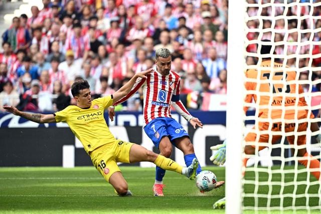 Girona's Spanish defender #16 Alejandro Frances tackles Atletico Madrid's French forward #07 Antoine Griezmann during the Spanish league football match between Club Atletico de Madrid and Girona FC at the Metroplitano stadium in Madrid on May 17, 2026. (Photo by Javier SORIANO / AFP)