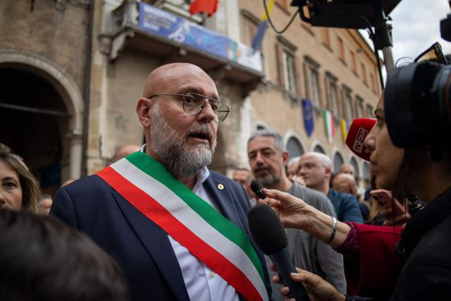 The mayor of Modena, Massimo Mezzetti, addresses journalists and residents at Piazza Grande in the center of Modena a day after a man drove his car into pedestrians injuring eight people, on May 17, 2026. Italian Prime Minister Giorgia Meloni visited people wounded by a driver with a history of mental health problems who ran over several pedestrians in the center of Modena, Northern Italy. The driver, a 31-year-old Italian man of Moroccan heritage, hit several people before crashing into a shop window, colliding head-on with a woman. (Photo by Federico SCOPPA / AFP)