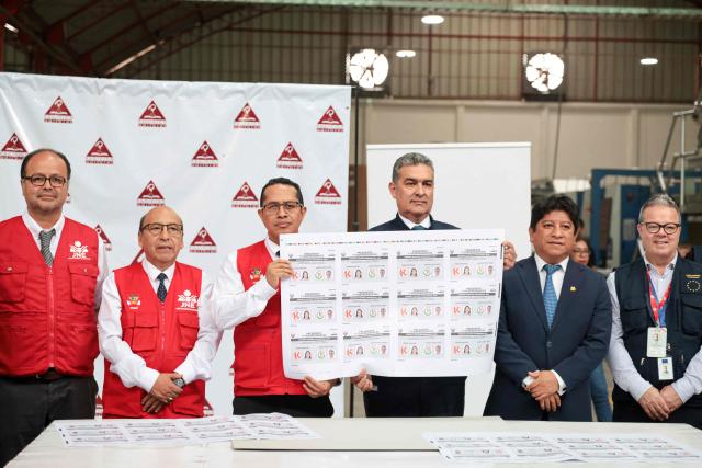 Peru's National Jury of Elections (JNE) president Roberto Burneo Bermejo (C, left) and the acting head of the National Office of Electoral Processes (ONPE), Bernardo Pachas, accompanied by other JNE officials and members of the European Union election observation mission, hold ballot papers during their printing at Pacifico Editores SAC in Lima on May 17, 2026. Right-wing candidate Keiko Fujimori and left-wing candidate Roberto Sanchez will face off on June 7 in Peru's presidential runoff, the electoral authority confirmed on May 17 when it officially proclaimed the results. (Photo by Connie FRANCE / AFP)