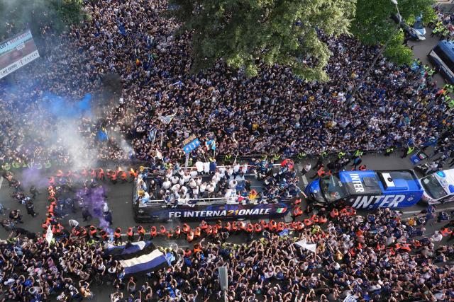 Inter Milan players parade on an open bus to celebrate their 21st scudetto (Italian Championship victory) with supporters outside San Siro stadium after the Italian Serie A football match between Inter Milan and Hellas Verona in Milan, on May 17, 2026. (Photo by Luca Bruno / POOL / AFP)