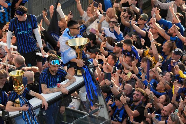 TOPSHOT - Inter Milan's Argentinian forward #10 Lautaro Martinez and teammates parade on an open bus to celebrate their 21st scudetto (Italian Championship victory) with supporters outside San Siro stadium after the Italian Serie A football match between Inter Milan and Hellas Verona in Milan, on May 17, 2026. (Photo by Luca Bruno / POOL / AFP)