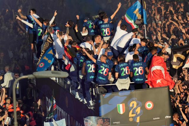 Inter Milan players parade on an open bus to celebrate their 21st scudetto (Italian Championship victory) with supporters outside San Siro stadium after the Italian Serie A football match between Inter Milan and Hellas Verona in Milan, on May 17, 2026. (Photo by Luca Bruno / POOL / AFP)