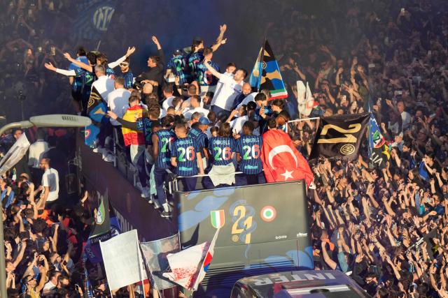 Inter Milan's players and staff parade on an open bus to celebrate their 21st scudetto (Italian Championship victory) with supporters outside San Siro stadium after the Italian Serie A football match between Inter Milan and Hellas Verona in Milan, on May 17, 2026. (Photo by Luca Bruno / POOL / AFP)