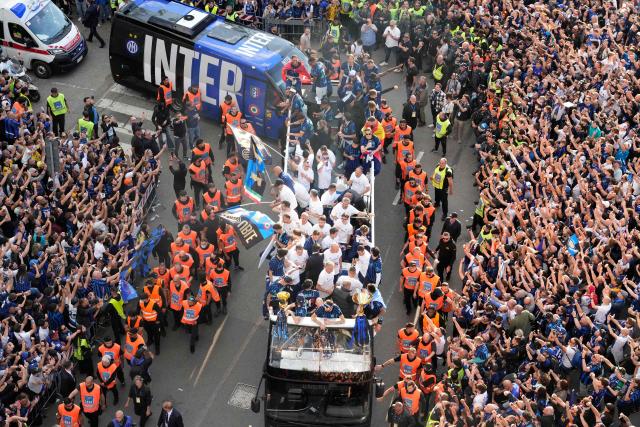 Inter Milan players parade on an open bus to celebrate their 21st scudetto (Italian Championship victory) with supporters outside San Siro stadium after the Italian Serie A football match between Inter Milan and Hellas Verona in Milan, on May 17, 2026. (Photo by Luca Bruno / POOL / AFP)