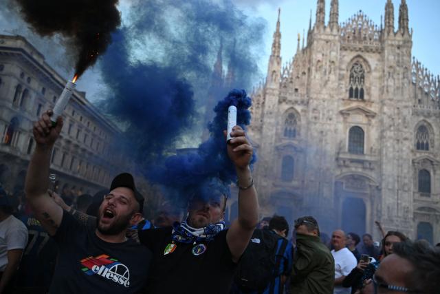 TOPSHOT - Inter Milan's supporters celebrate their 21st scudetto (Italian Championship victory) at Piazza Duomo in Milan before the arrival of the players on an open bus following the Italian Serie A football match between Inter Milan and Hellas Verona, on May 17, 2026. (Photo by PIERO CRUCIATTI / AFP)
