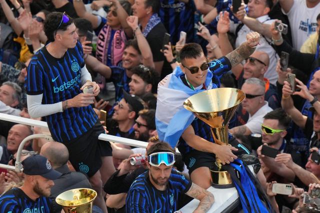 Inter Milan's Argentinian forward #10 Lautaro Martinez and teammates parade on an open bus to celebrate their 21st scudetto (Italian Championship victory) with supporters outside San Siro stadium after the Italian Serie A football match between Inter Milan and Hellas Verona in Milan, on May 17, 2026. (Photo by Luca Bruno / POOL / AFP)