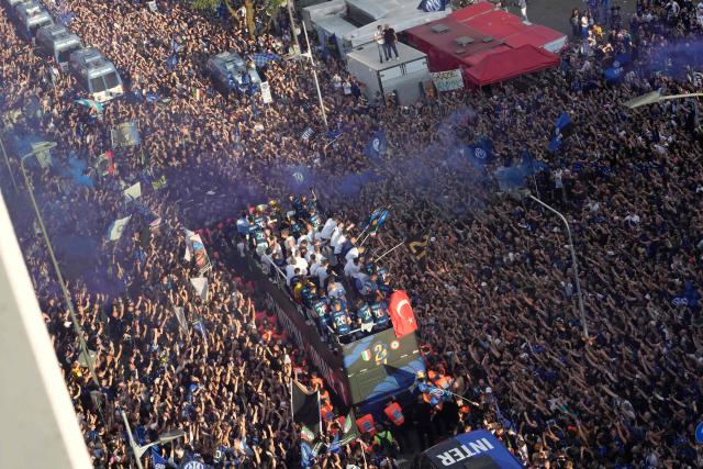 Inter Milan players parade on an open bus to celebrate their 21st scudetto (Italian Championship victory) with supporters outside San Siro stadium after the Italian Serie A football match between Inter Milan and Hellas Verona in Milan, on May 17, 2026. (Photo by Luca Bruno / POOL / AFP)