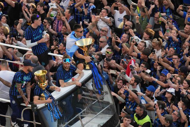 Inter Milan's Argentinian forward #10 Lautaro Martinez and teammates parade on an open bus to celebrate their 21st scudetto (Italian Championship victory) with supporters outside San Siro stadium after the Italian Serie A football match between Inter Milan and Hellas Verona in Milan, on May 17, 2026. (Photo by Luca Bruno / POOL / AFP)
