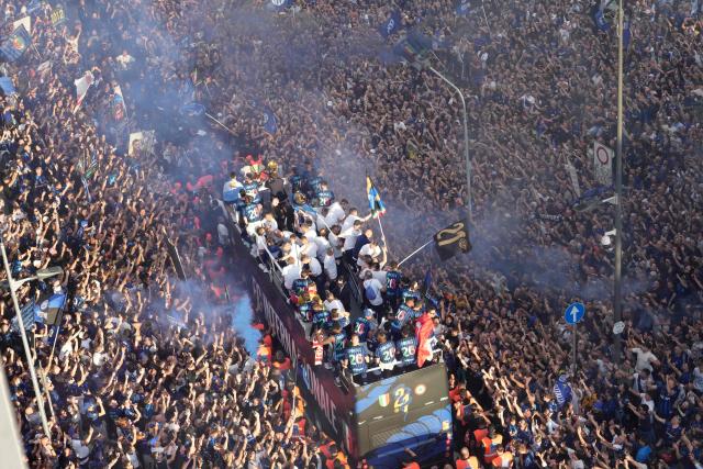 Inter Milan players parade on an open bus to celebrate their 21st scudetto (Italian Championship victory) with supporters outside San Siro stadium after the Italian Serie A football match between Inter Milan and Hellas Verona in Milan, on May 17, 2026. (Photo by Luca Bruno / POOL / AFP)