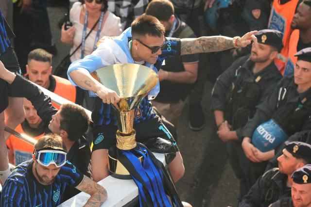Inter Milan's Argentinian forward #10 Lautaro Martinez and teammates parade on an open bus to celebrate their 21st scudetto (Italian Championship victory) with supporters outside San Siro stadium after the Italian Serie A football match between Inter Milan and Hellas Verona in Milan, on May 17, 2026. (Photo by Luca Bruno / POOL / AFP)