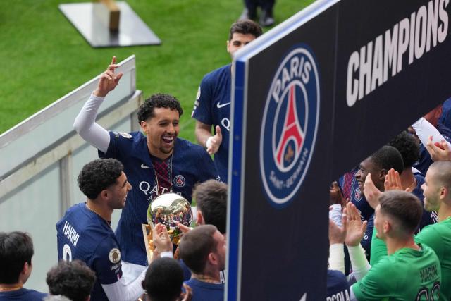 Paris Saint-Germain's Brazilian defender #05 Marquinhos (L) celebrates with teammates winning the French Ligue 1 championship, ahead of the French L1 football match between Paris FC and Paris Saint-Germain (PSG) at the Stade Jean-Bouin in Paris on May 17, 2026. (Photo by Dimitar DILKOFF / AFP)